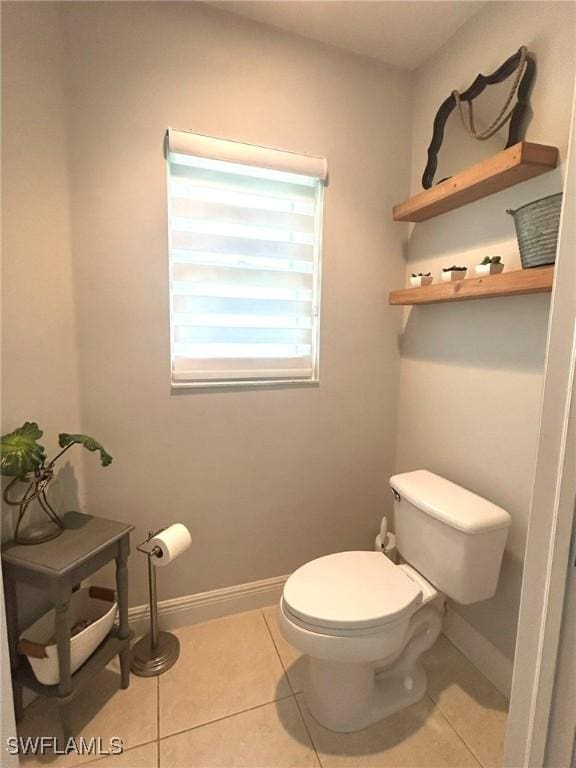 bathroom featuring baseboards, toilet, and tile patterned flooring