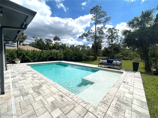 pool with a patio, a lawn, and an outdoor hangout area