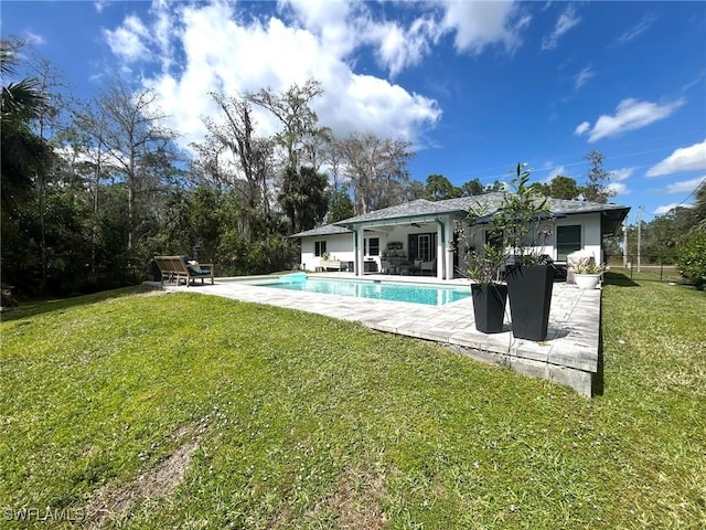 outdoor pool featuring a patio area, a lawn, and ceiling fan