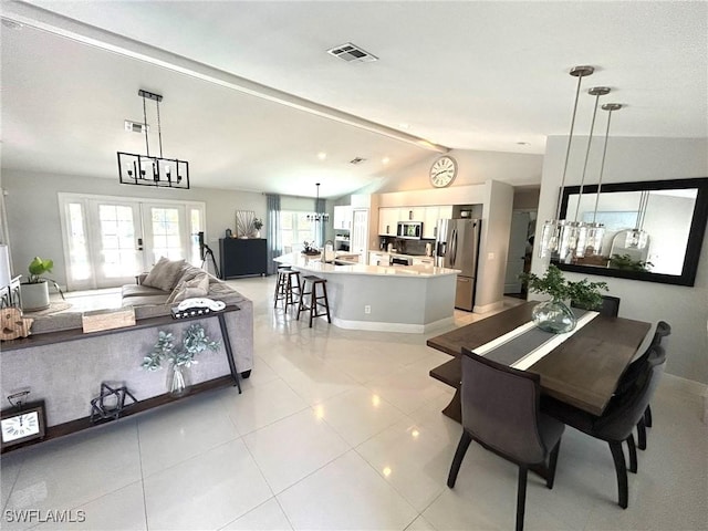 dining area featuring visible vents, french doors, light tile patterned floors, baseboards, and vaulted ceiling