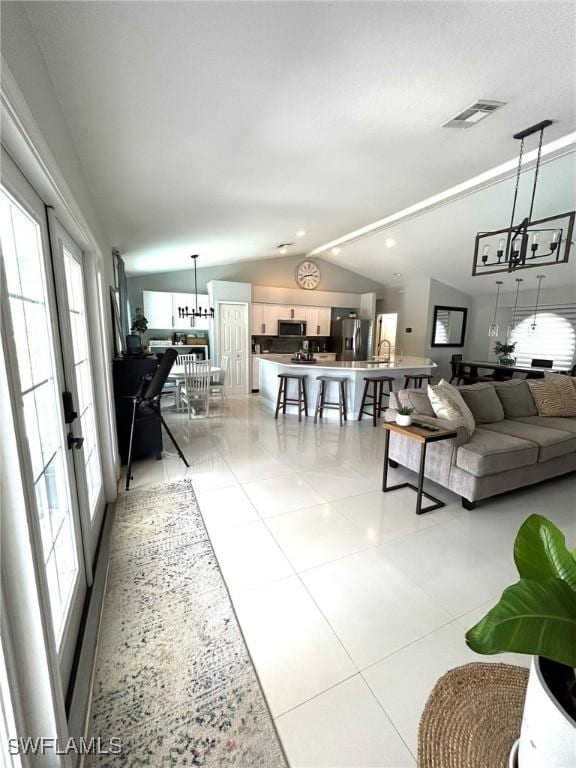 living room featuring visible vents, recessed lighting, an inviting chandelier, light tile patterned flooring, and lofted ceiling