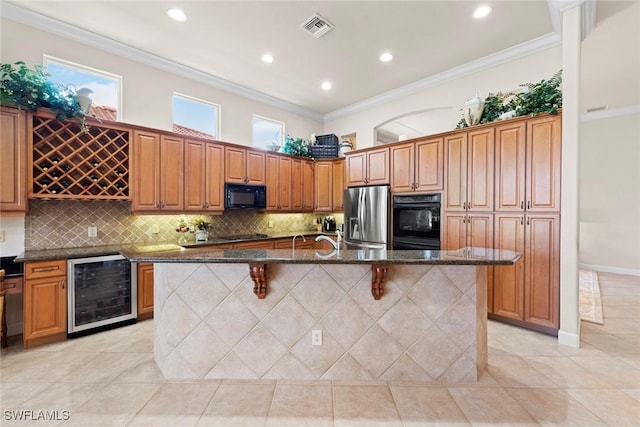 kitchen with visible vents, wine cooler, ornamental molding, a kitchen breakfast bar, and black appliances