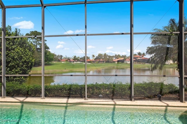 view of swimming pool with glass enclosure and a water view