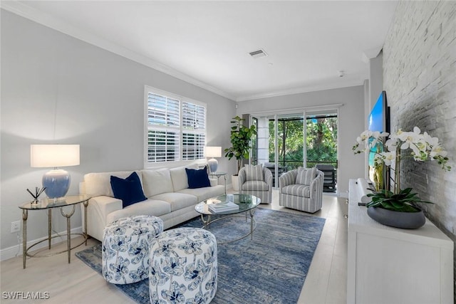 living area with light wood-type flooring, visible vents, crown molding, and baseboards