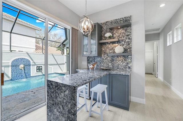 interior space with a notable chandelier, tasteful backsplash, recessed lighting, hanging light fixtures, and baseboards