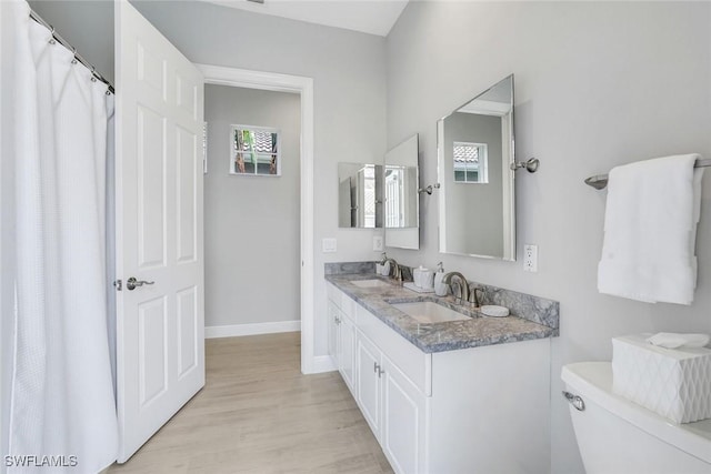 full bath featuring baseboards, a sink, toilet, and wood finished floors