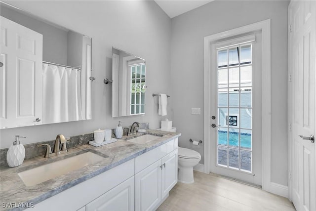 full bathroom with plenty of natural light, a sink, and toilet