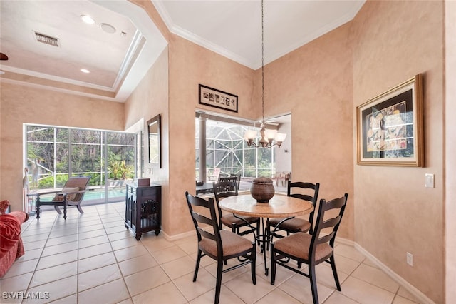 dining area with a chandelier, light tile patterned floors, a towering ceiling, baseboards, and crown molding