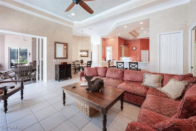 living area with ornamental molding, a tray ceiling, a towering ceiling, and light tile patterned floors