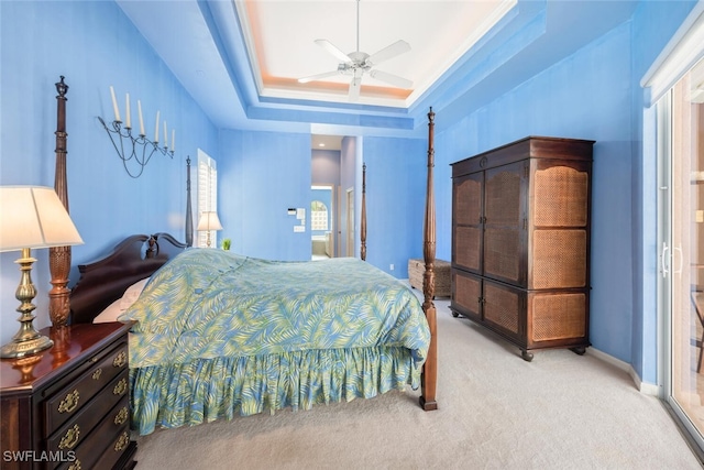 bedroom featuring a tray ceiling, light carpet, and baseboards