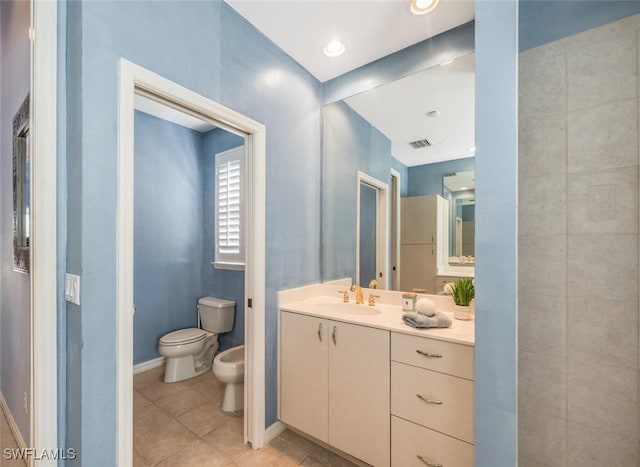 bathroom featuring visible vents, toilet, tile patterned floors, vanity, and a bidet