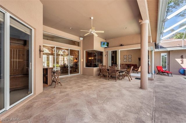 view of patio / terrace with outdoor dining area, a lanai, and a ceiling fan