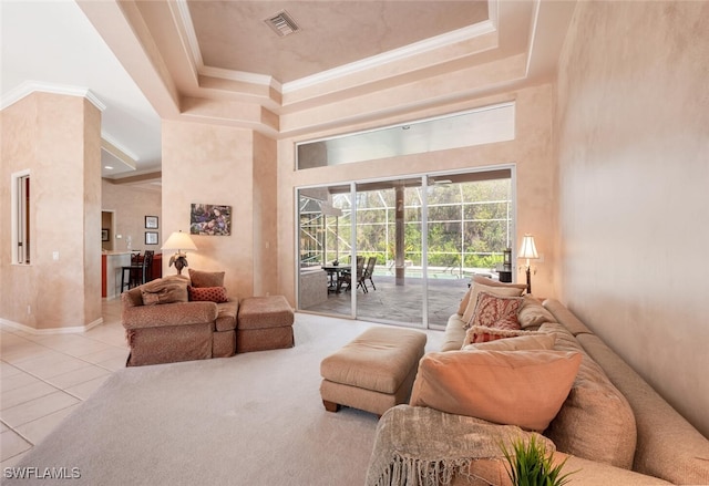 carpeted living area featuring a raised ceiling, visible vents, a high ceiling, ornamental molding, and tile patterned floors