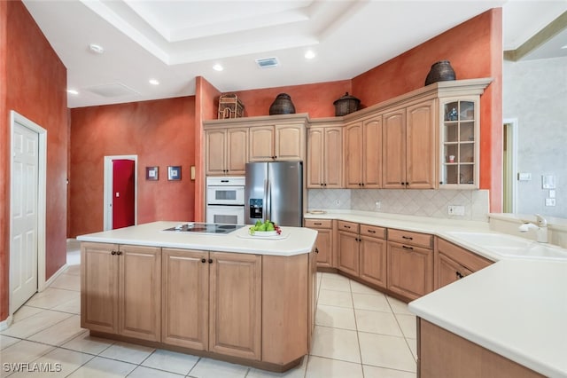 kitchen with white double oven, a kitchen island, a sink, stainless steel refrigerator with ice dispenser, and tasteful backsplash