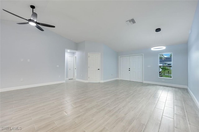 unfurnished living room featuring visible vents, vaulted ceiling, ceiling fan, light wood-type flooring, and baseboards