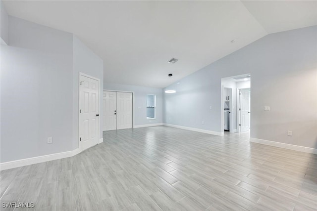 unfurnished living room featuring vaulted ceiling, light wood-type flooring, visible vents, and baseboards