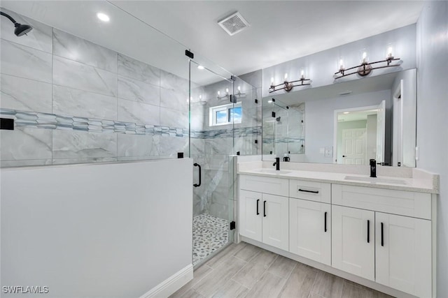 full bathroom with a stall shower, visible vents, a sink, and double vanity