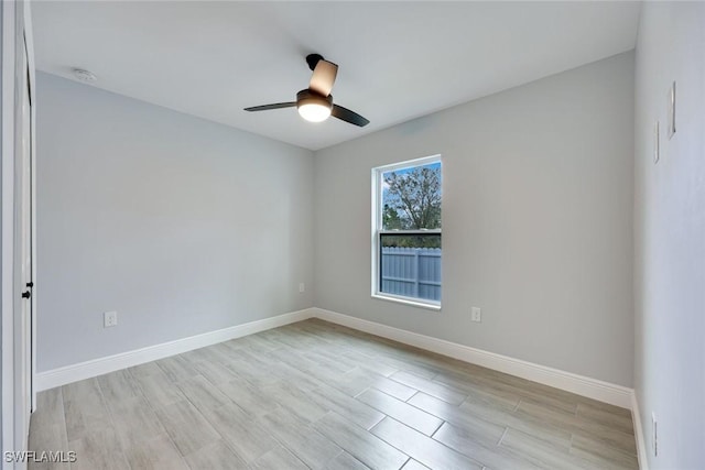 unfurnished room featuring ceiling fan, light wood finished floors, and baseboards