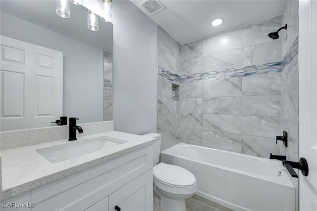 full bath with visible vents, vanity, toilet, and tub / shower combination