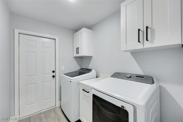 washroom with cabinet space, washer and clothes dryer, and light wood-style floors