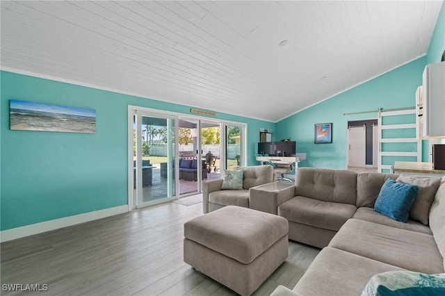 living area featuring french doors, a barn door, vaulted ceiling, light wood-type flooring, and baseboards