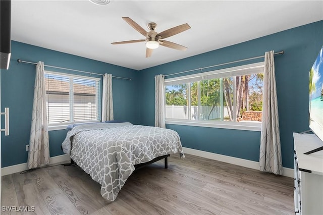 bedroom featuring ceiling fan, wood finished floors, and baseboards