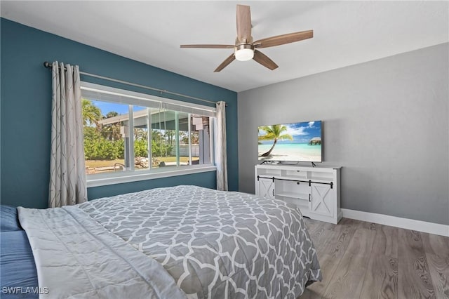 bedroom featuring ceiling fan, wood finished floors, and baseboards