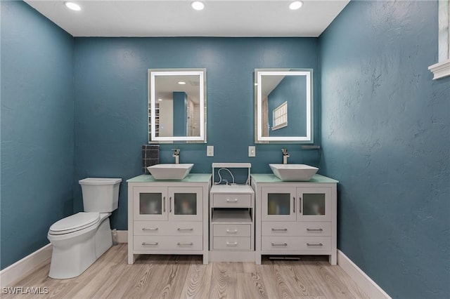 bathroom featuring toilet, wood finished floors, vanity, and baseboards