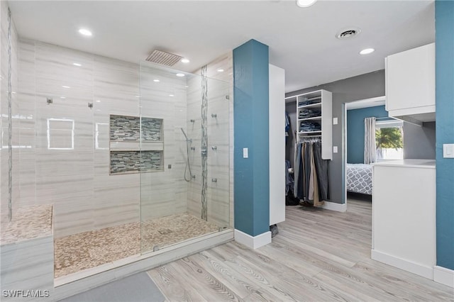 bathroom with recessed lighting, visible vents, a stall shower, wood finished floors, and baseboards