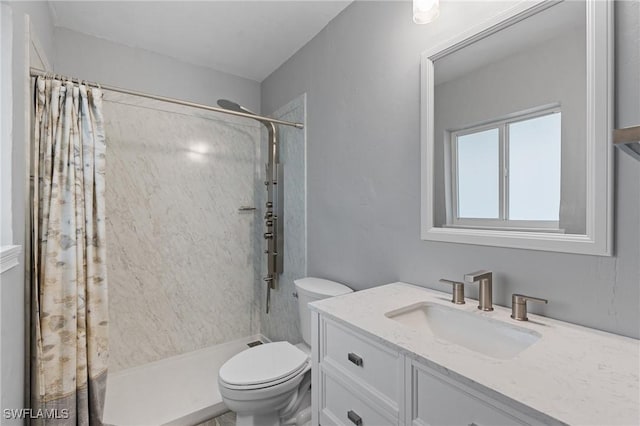 full bath featuring a stall shower, vanity, and toilet