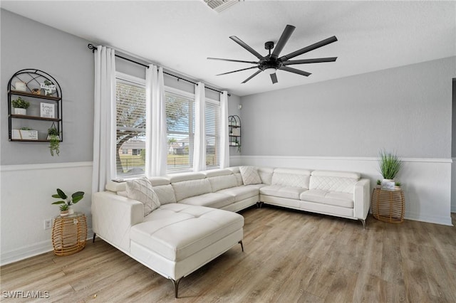 living area with ceiling fan, visible vents, and wood finished floors