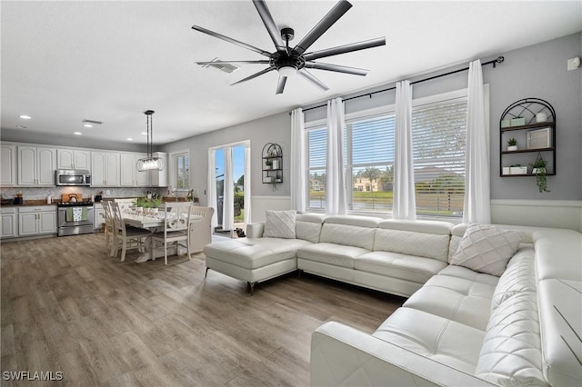 living area with recessed lighting, wood finished floors, visible vents, and a ceiling fan