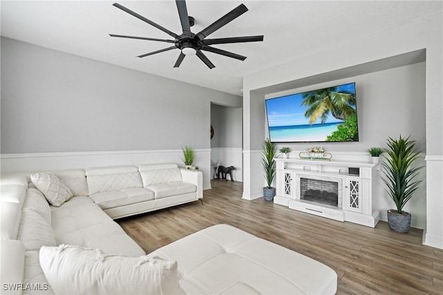 living room with ceiling fan, a fireplace, and wood finished floors