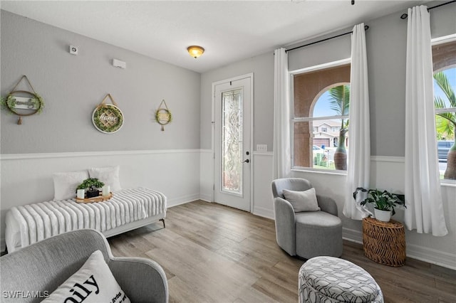 interior space featuring baseboards, wood finished floors, and a healthy amount of sunlight