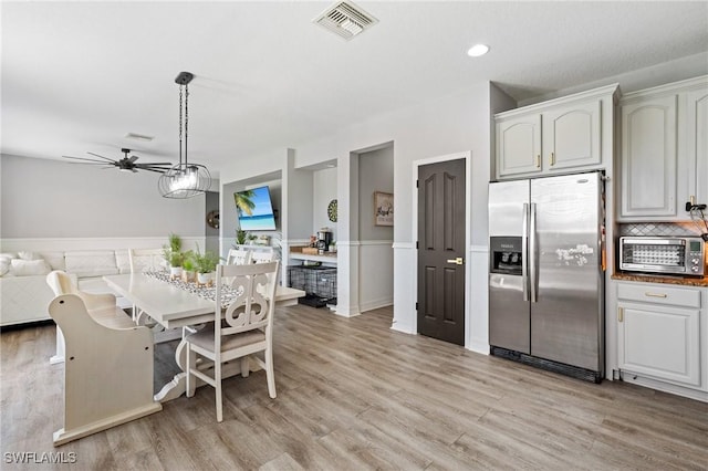 dining area featuring ceiling fan, a toaster, visible vents, and light wood-style flooring