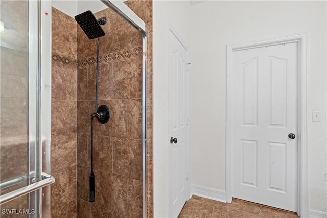 full bath with a shower stall and baseboards