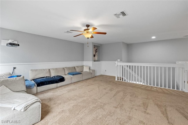 carpeted living area featuring a ceiling fan and visible vents