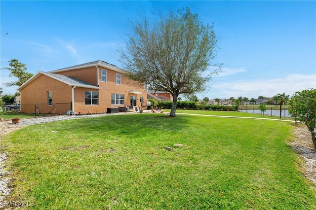 view of yard with a patio area, cooling unit, fence, and a water view