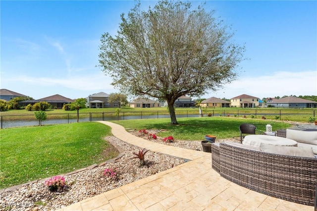 view of patio / terrace with a residential view, a water view, and fence