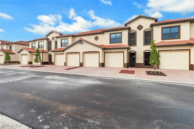 view of front of property with a garage, decorative driveway, and stucco siding