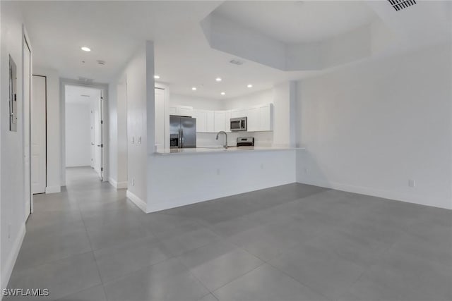 kitchen featuring white cabinets, light countertops, stainless steel appliances, a sink, and recessed lighting