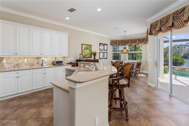 kitchen featuring plenty of natural light, a sink, and crown molding