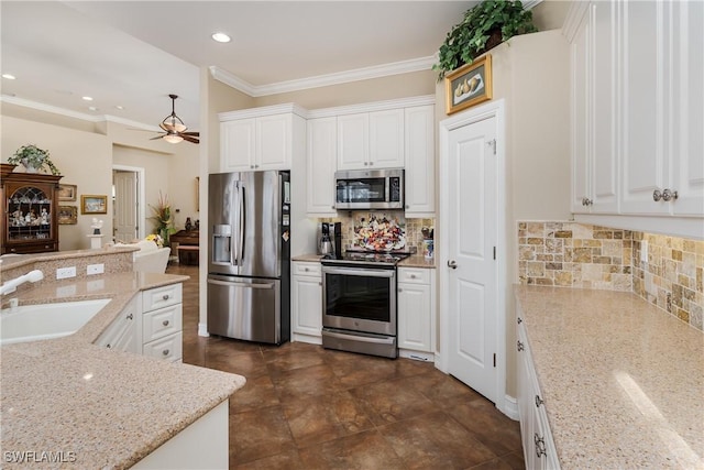 kitchen featuring tasteful backsplash, stainless steel appliances, crown molding, white cabinetry, and a sink