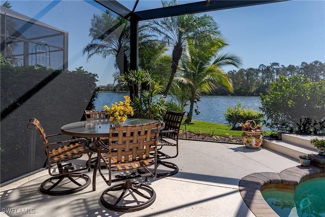 view of patio / terrace featuring a lanai, a water view, and outdoor dining space