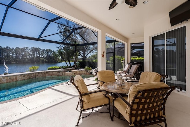 view of patio / terrace featuring a water view, a ceiling fan, an in ground hot tub, a lanai, and an outdoor pool