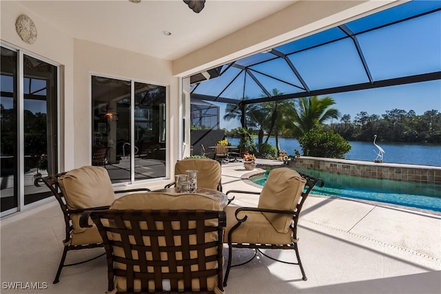 view of patio with glass enclosure, outdoor dining space, and a water view