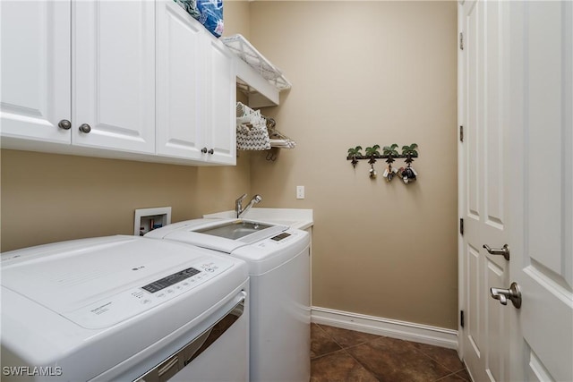 laundry room featuring cabinet space, a sink, independent washer and dryer, dark tile patterned floors, and baseboards