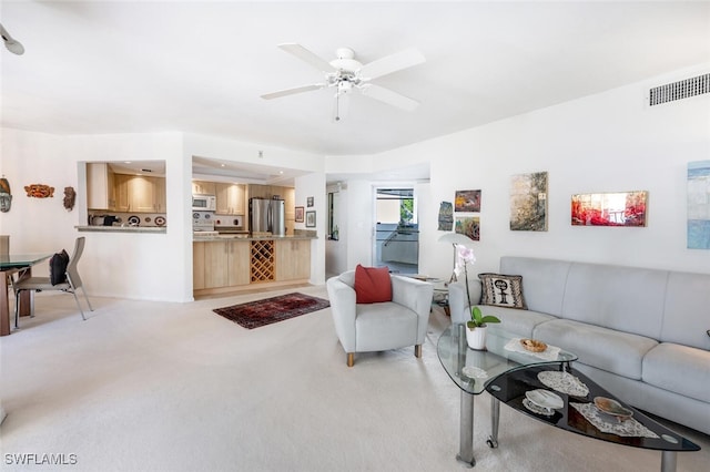 living area featuring light carpet, visible vents, and a ceiling fan