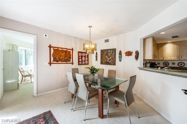 dining room with a chandelier, light carpet, visible vents, and baseboards