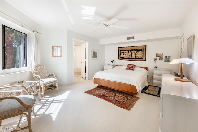 bedroom with a skylight, visible vents, ensuite bath, ceiling fan, and carpet flooring